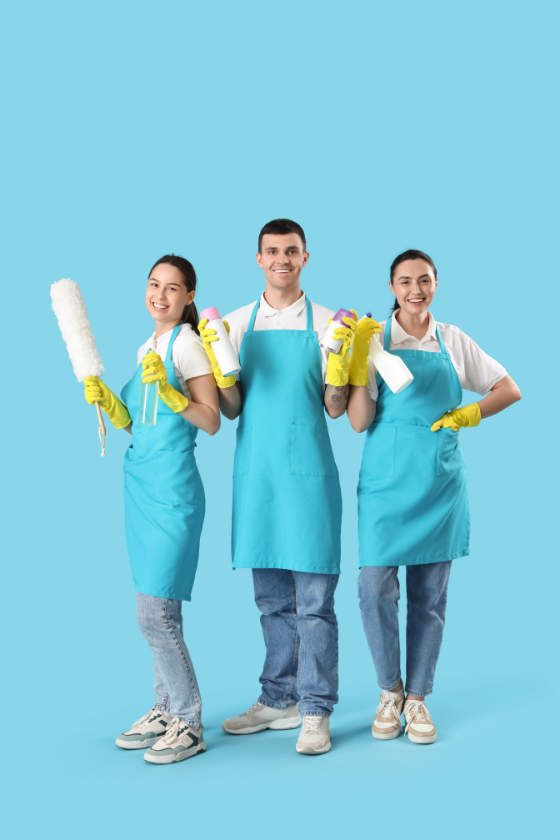 A group of cleaners are standing next to each other holding cleaning supplies.