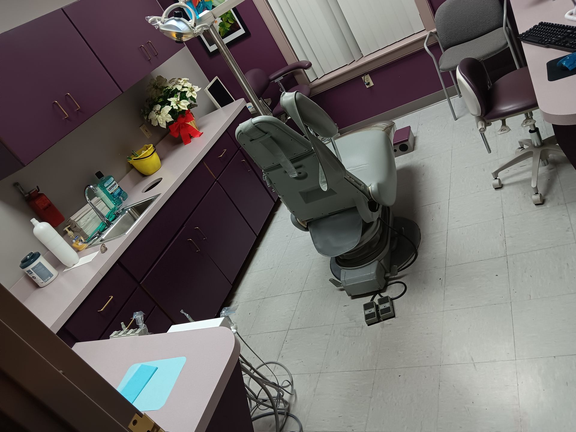 A dental office with purple cabinets and a dental chair