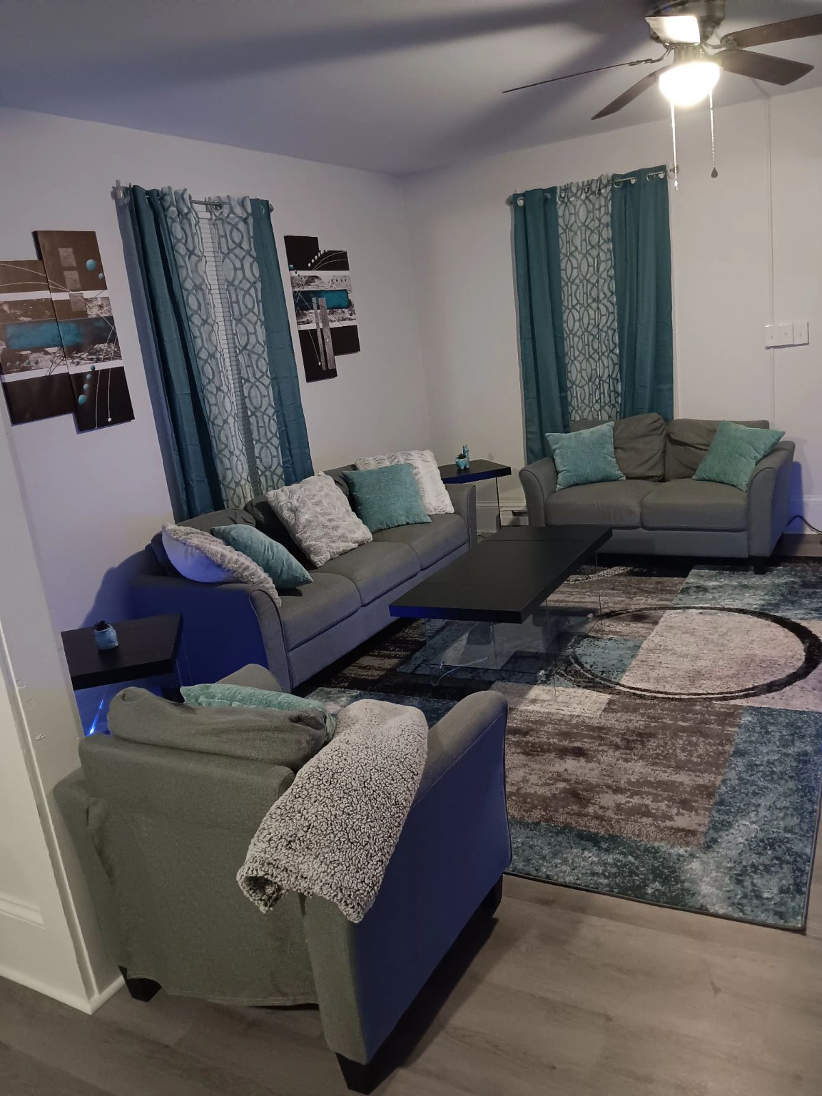 A living room filled with furniture and a ceiling fan.