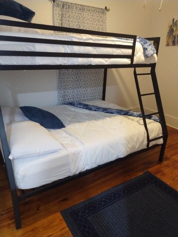 A bunk bed with white sheets and blue pillows