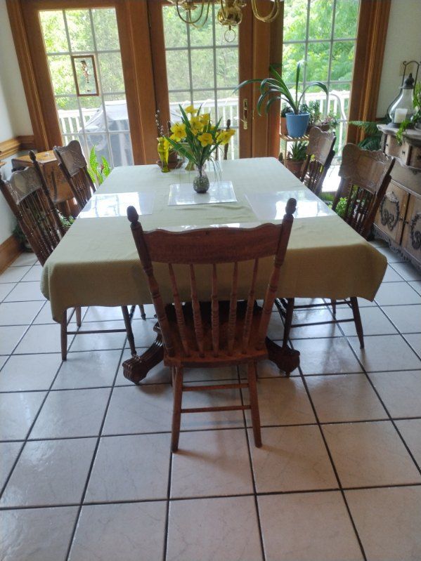 A dining room table with a vase of flowers on it