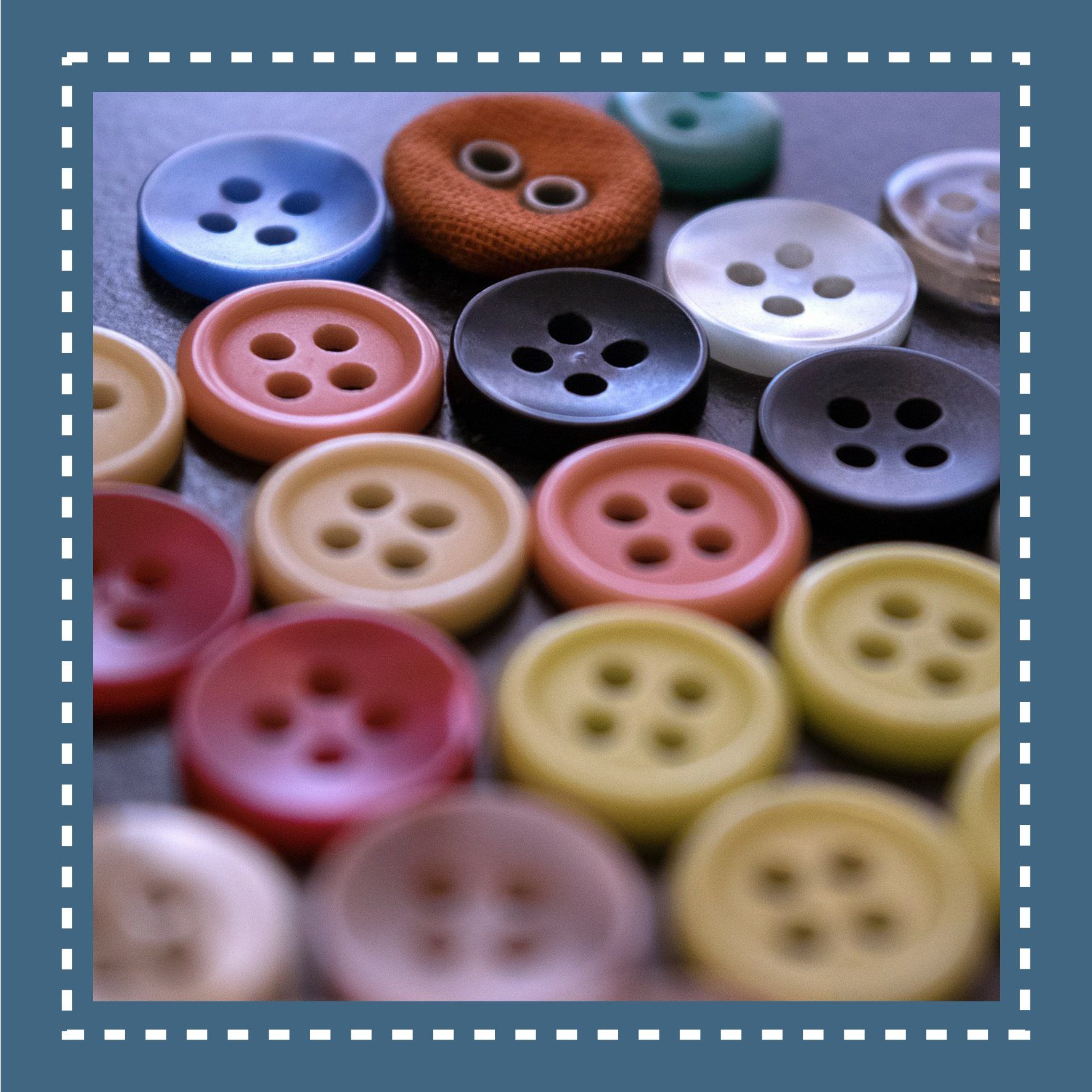 Close-up of various colorful buttons, including blue, orange, black, and red, scattered on a surface.