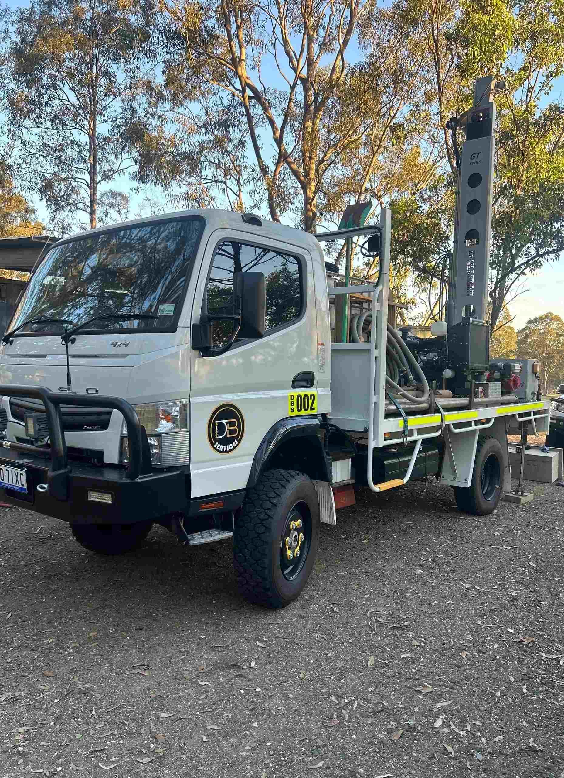 A construction worker is using a machine to drill a hole in a concrete pillar.
