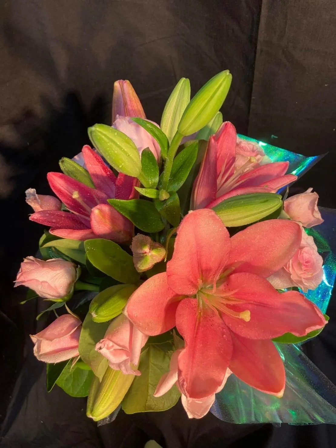 A Bouquet of Pink Lilies and Pink Roses Wrapped in Plastic — Wingham Nursery and Florist PTY Ltd In Wingham, NSW