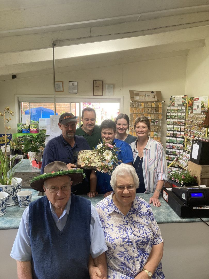 A Bunch of Flowers Are Sitting on a Wooden Table — Wingham Nursery and Florist PTY Ltd In Wingham, NSW