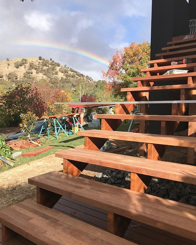 A Wooden Staircase With A Rainbow In The Background — Hardwood Projects in Canberra, ACT