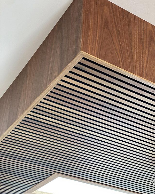 A Close Up Of A Wooden And Metal Ceiling With A Light On It — Hardwood Projects in Canberra, ACT