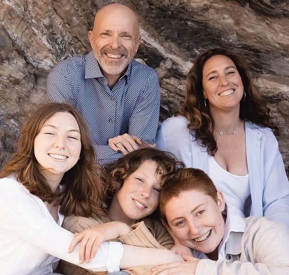 A man and two women are standing next to each other holding cleaning supplies.