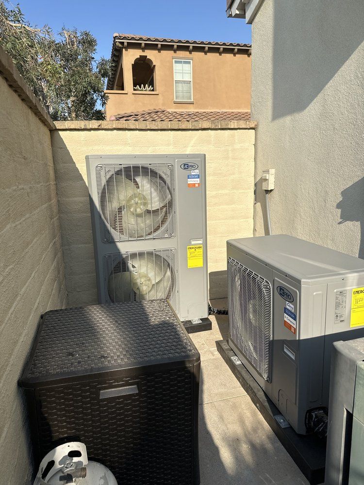 Two air conditioners are sitting next to each other on the side of a building.