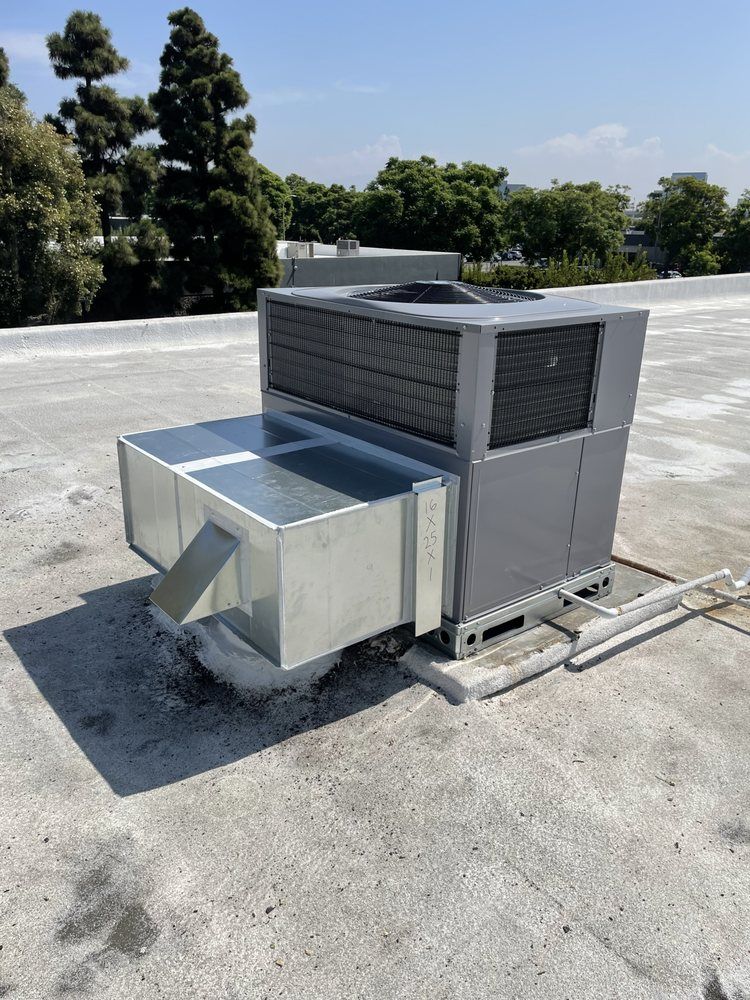 A large air conditioner is sitting on top of a roof.
