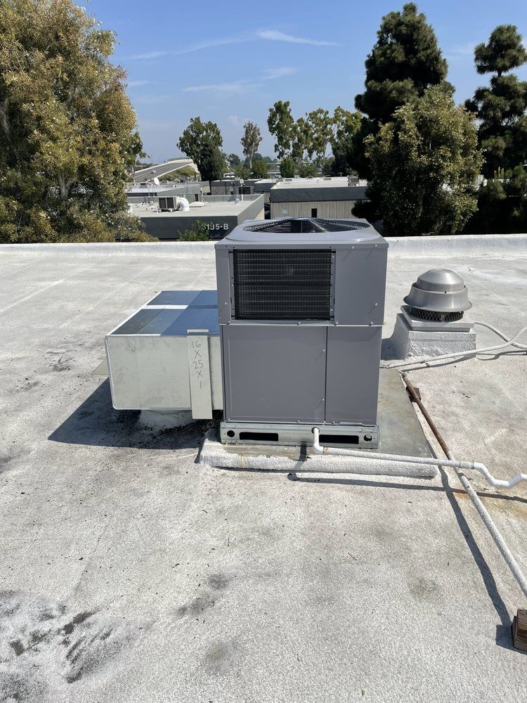 A large air conditioner is sitting on top of a roof.