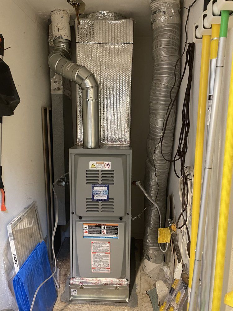 A furnace is sitting in a corner of a room.