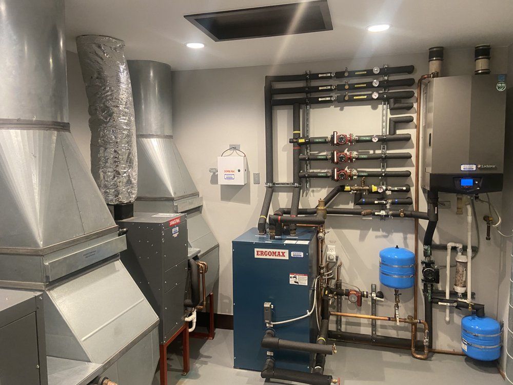 A room with a lot of pipes and a blue boiler.