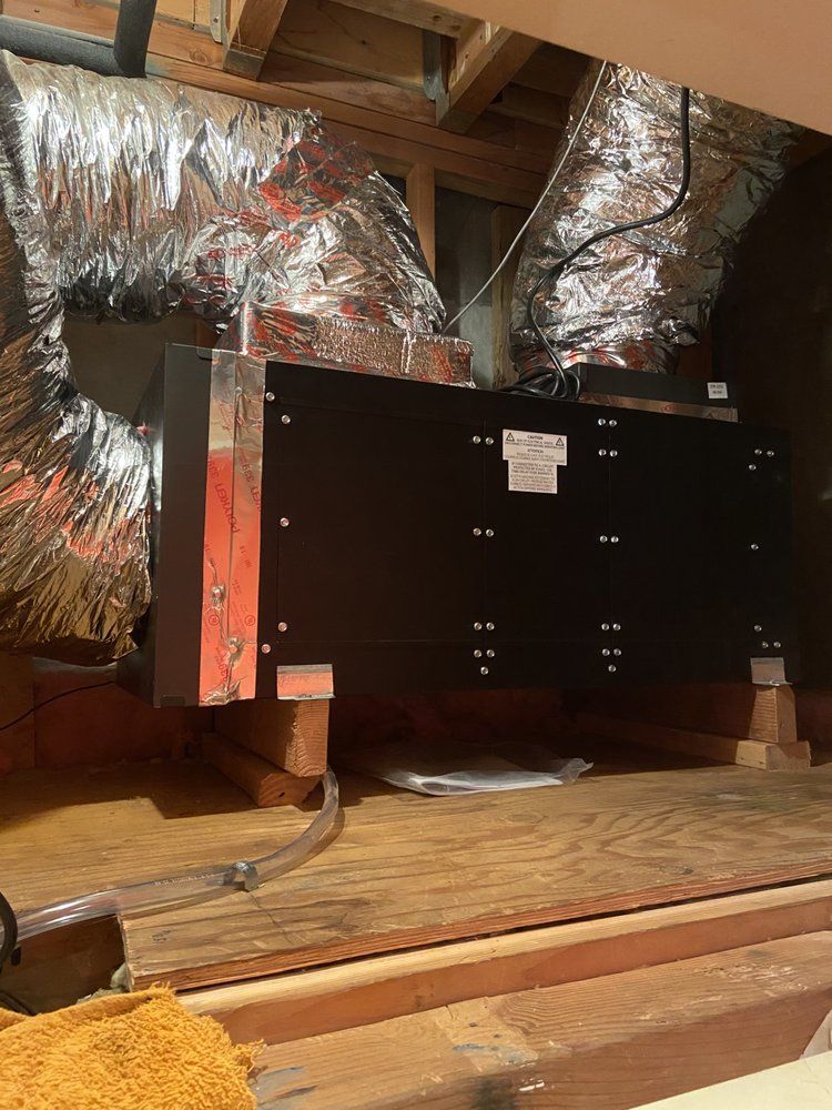 A black box is sitting on top of a wooden floor in a room.