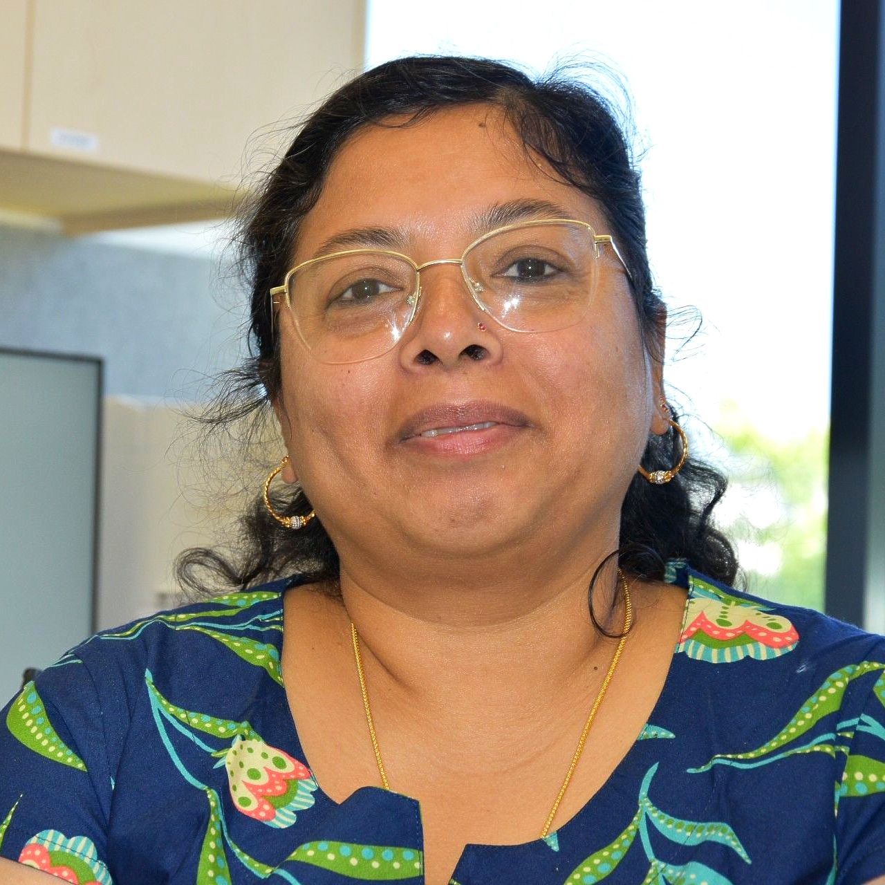 A woman wearing glasses and a floral shirt