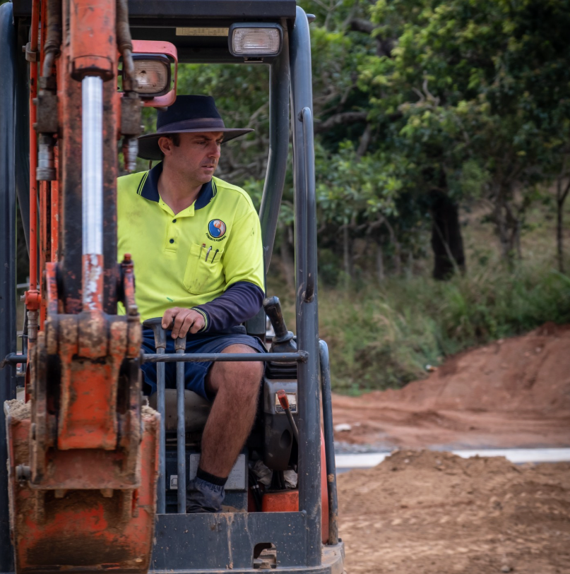 Two Workers in Blue Uniforms With High-visibility Vests Work on Black Pipe — Dunnerite Plumbing in Edmonton, QLD
