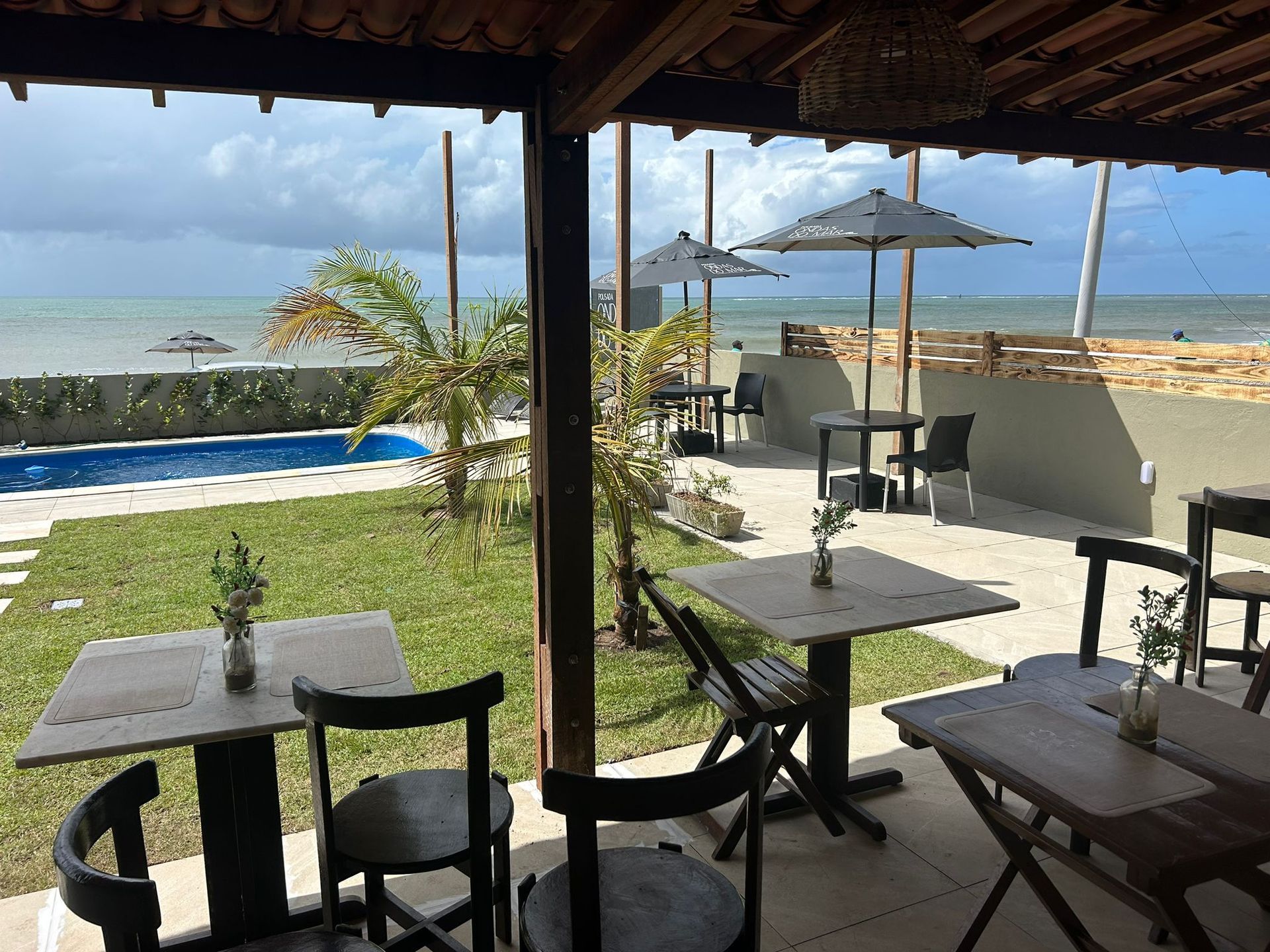 Um restaurante com mesas e cadeiras com vista para o oceano