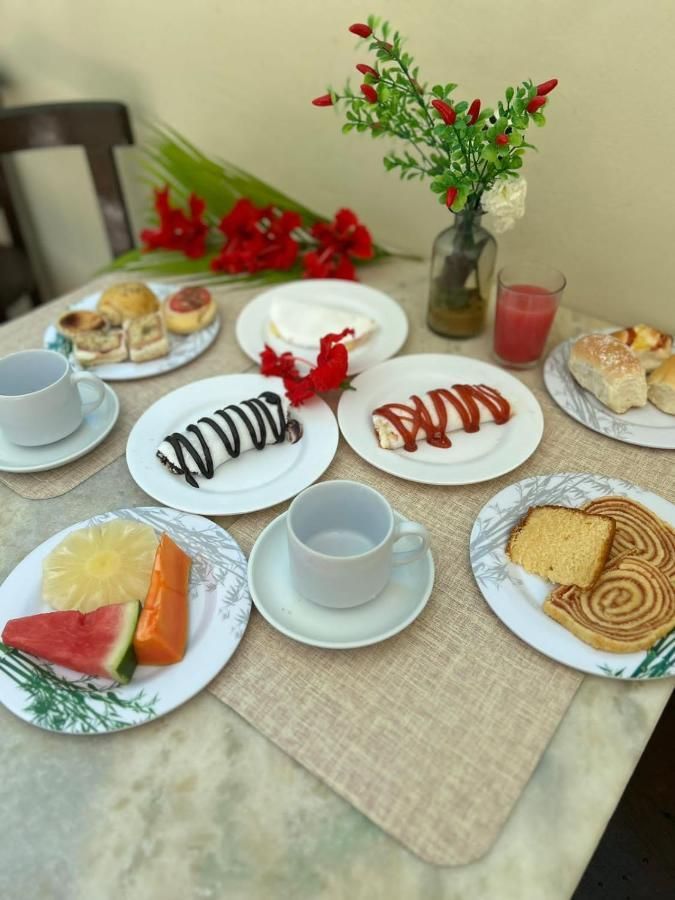 Uma mesa coberta com pratos de comida e um vaso de flores