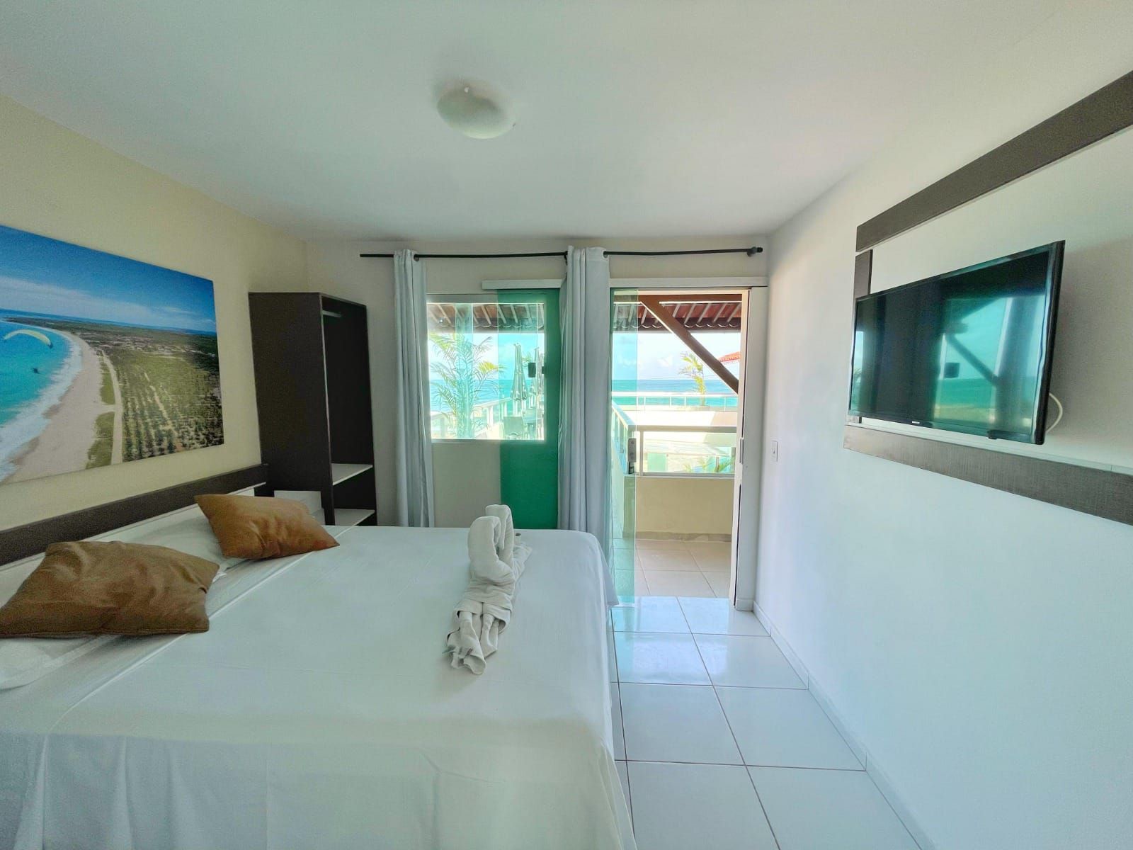 Um quarto de hotel com uma cama grande e uma TV de tela plana.