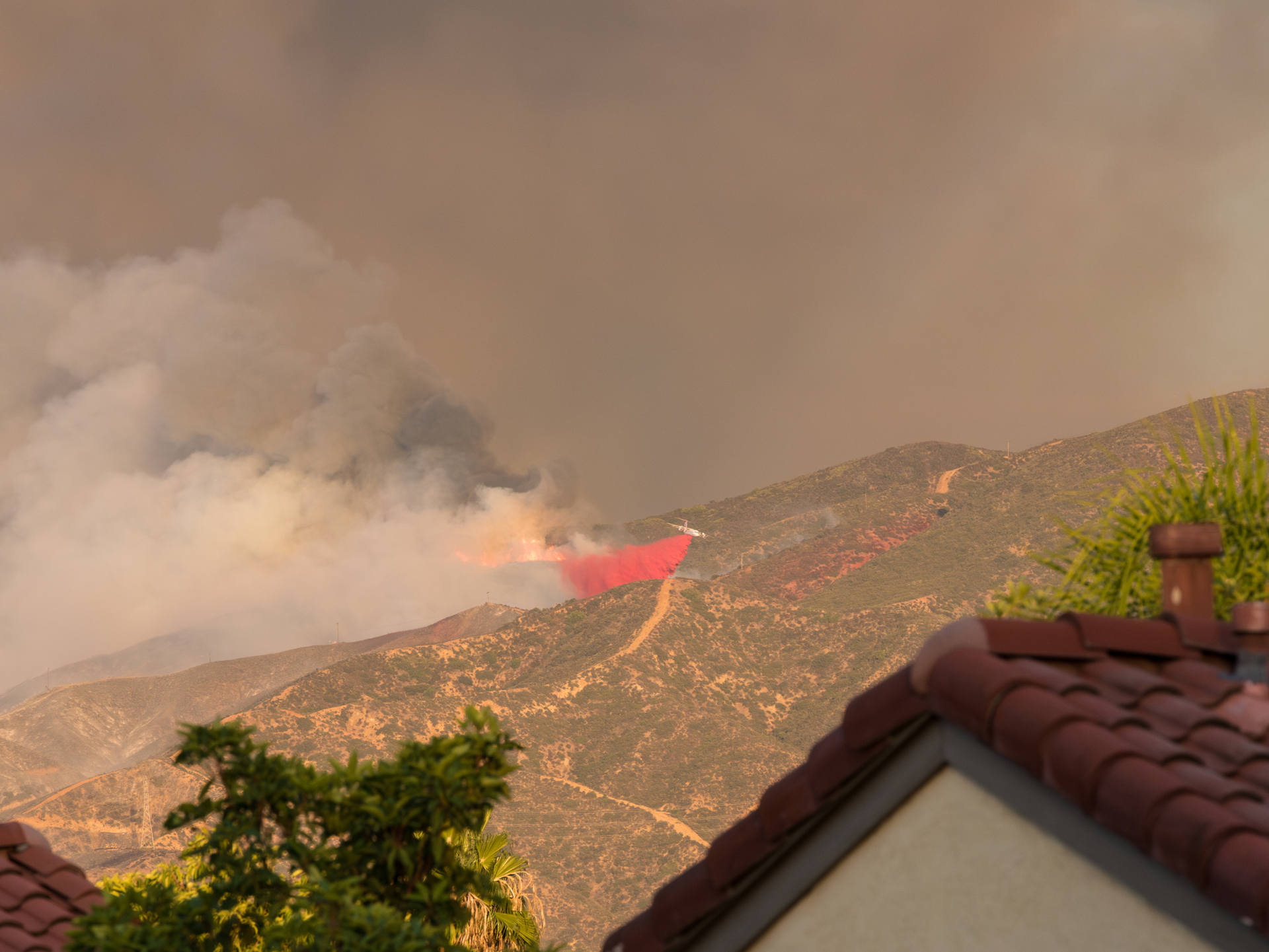 firefighter helicopter creating barriers to protect homes from natural wildfire
