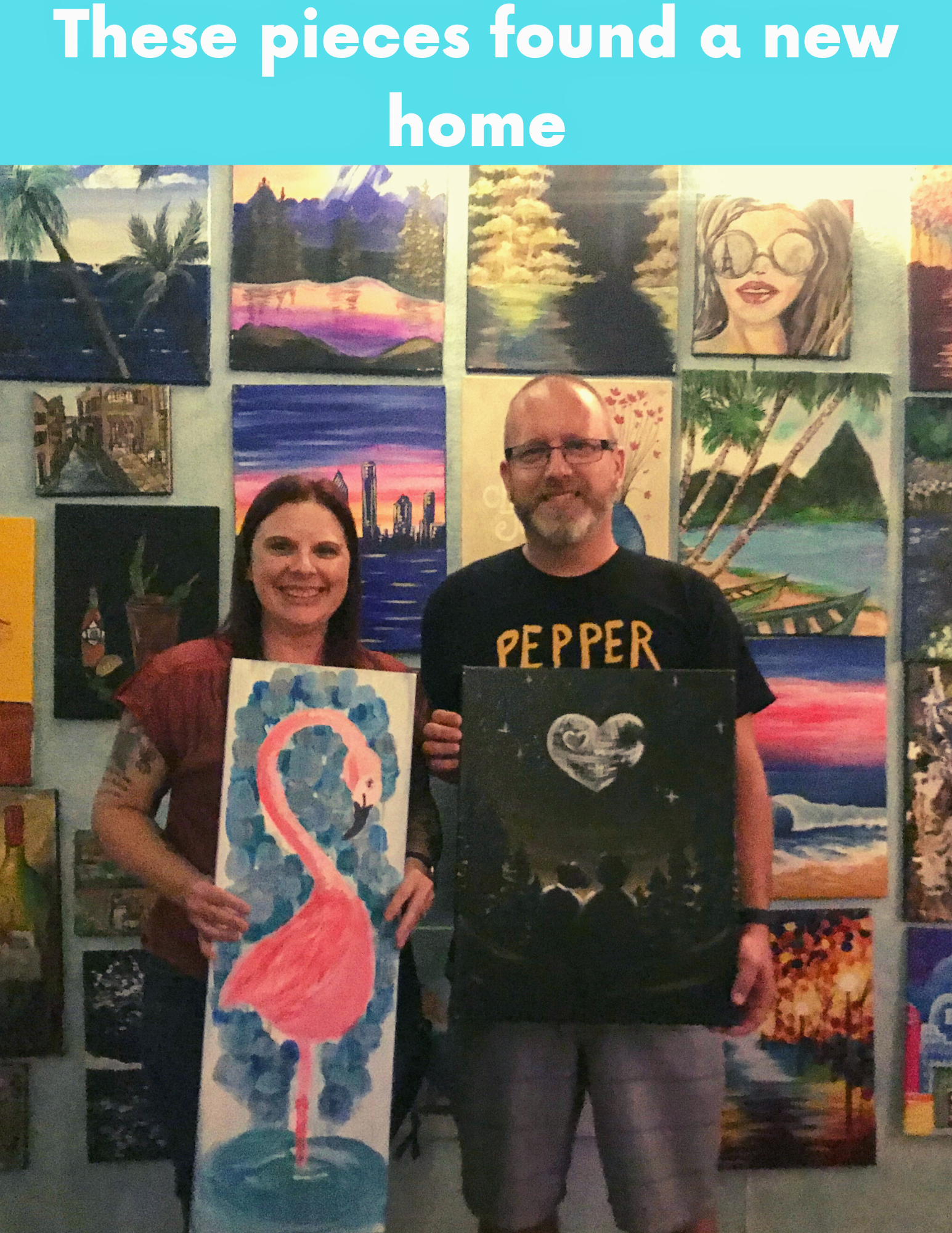 A man and woman holding a flamingo painting in front of a wall of paintings.