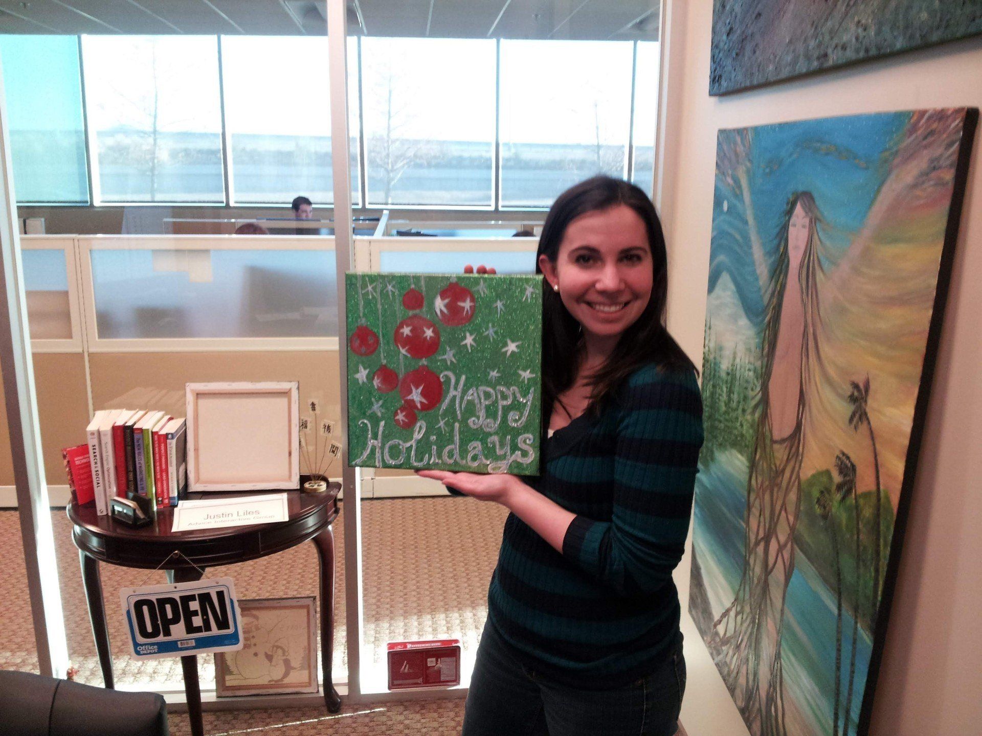 A woman holding a sign that says happy holidays