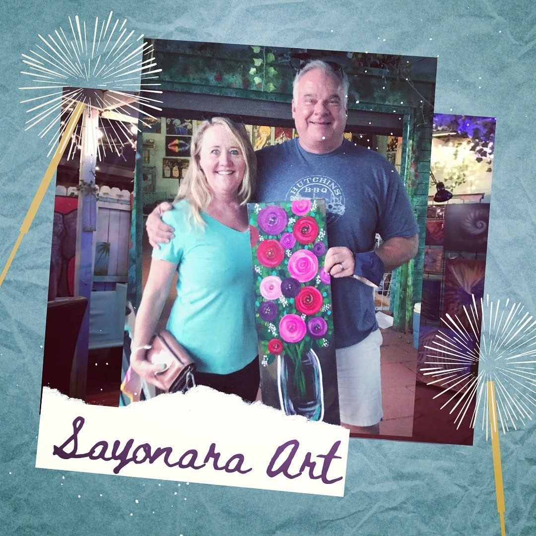 A man and woman are posing for a picture with a sign that says sayohara art