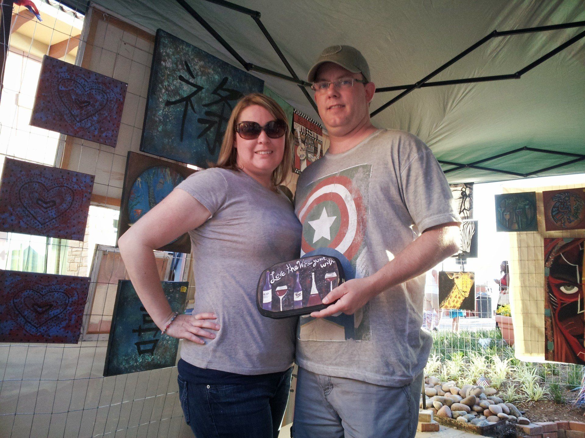A man in a captain america shirt stands next to a woman