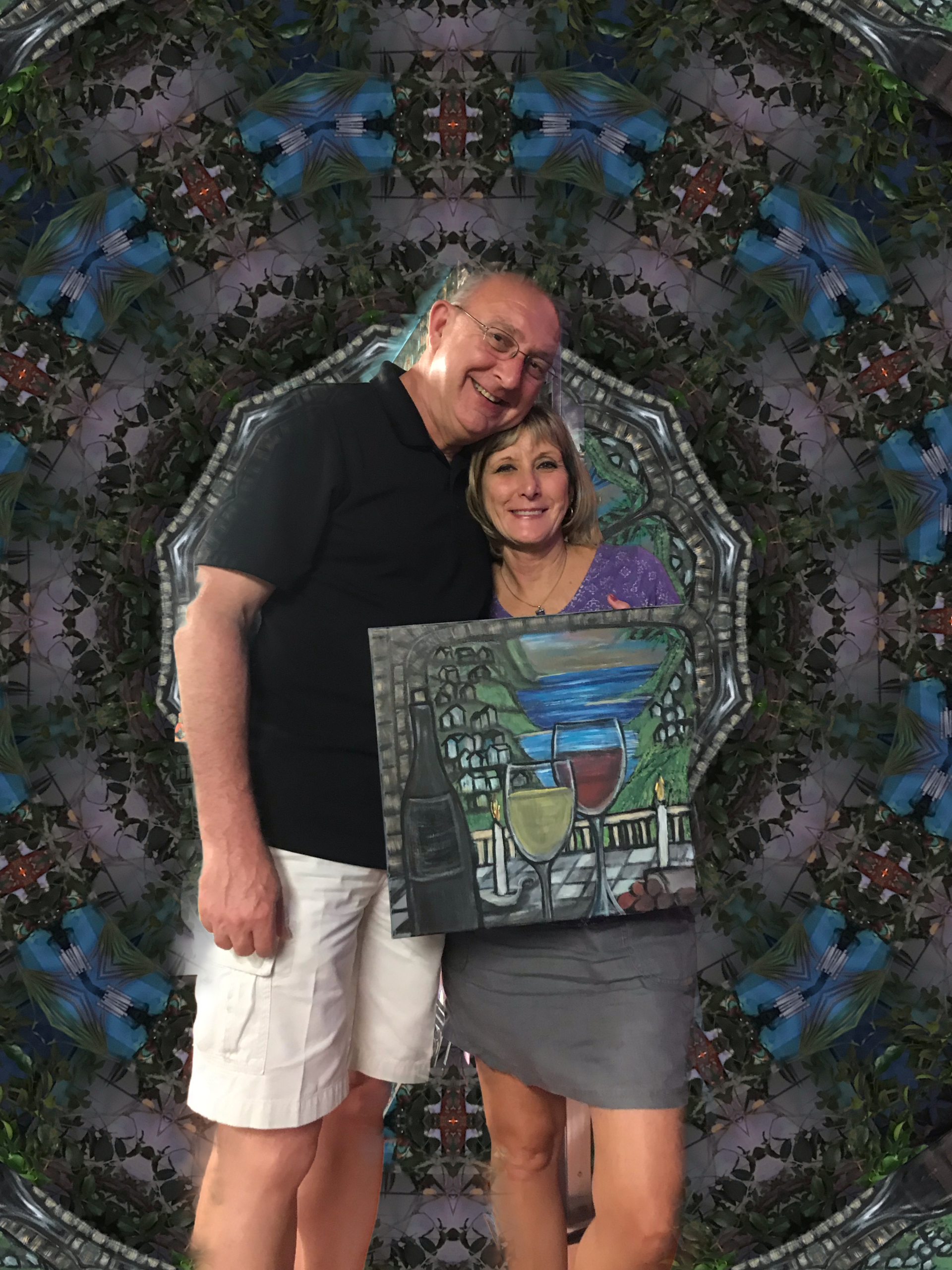 A man and a woman are standing next to each other holding a painting.