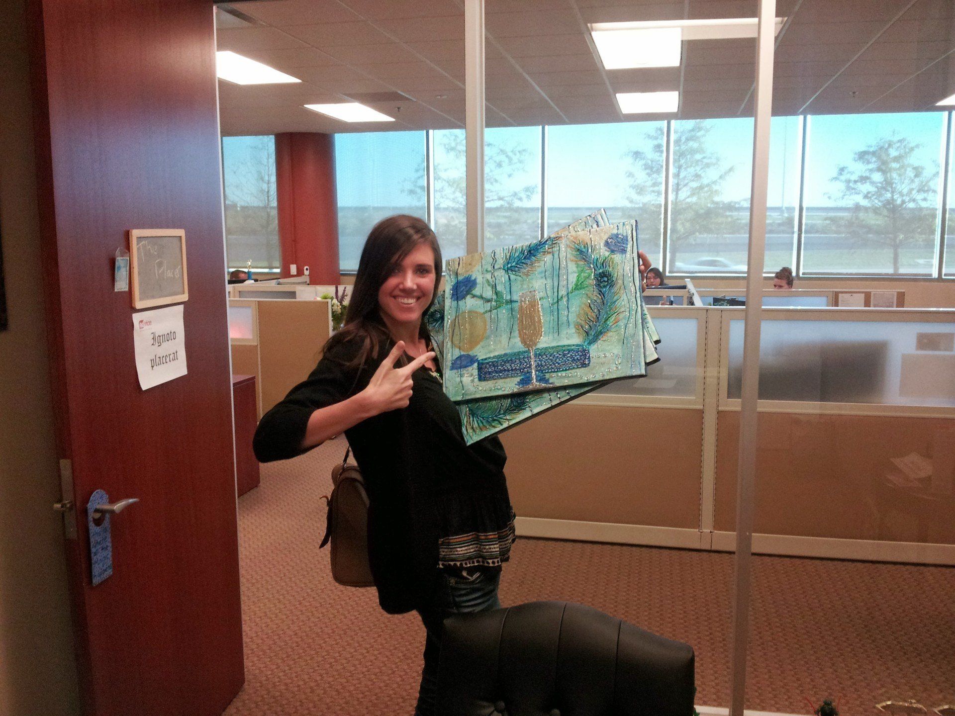 A woman in an office holding a piece of art