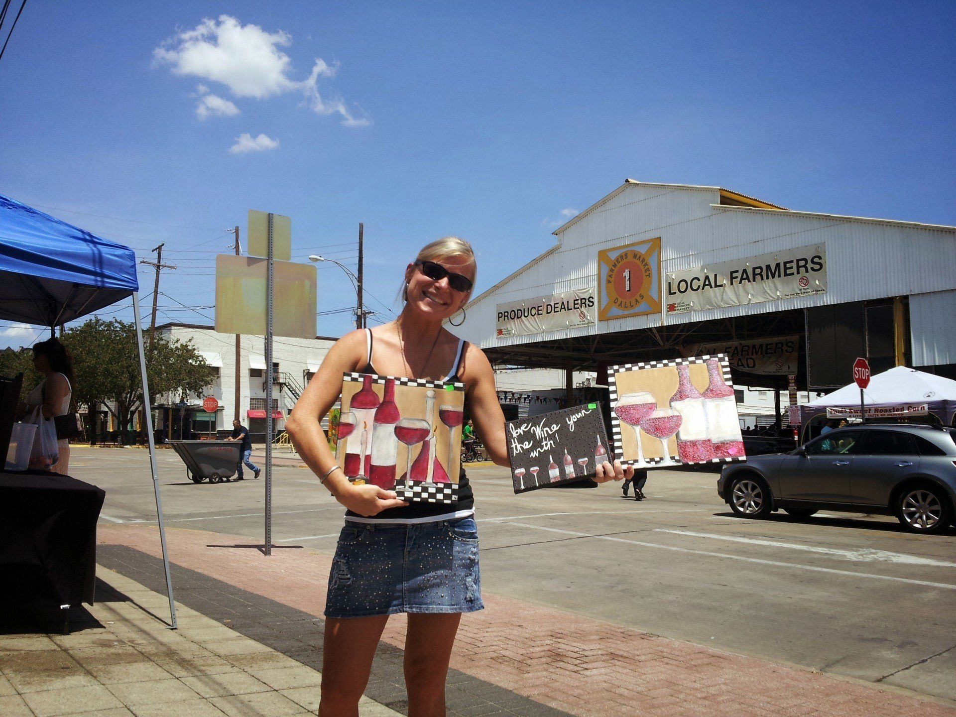 A woman stands in front of a building that says local farmers