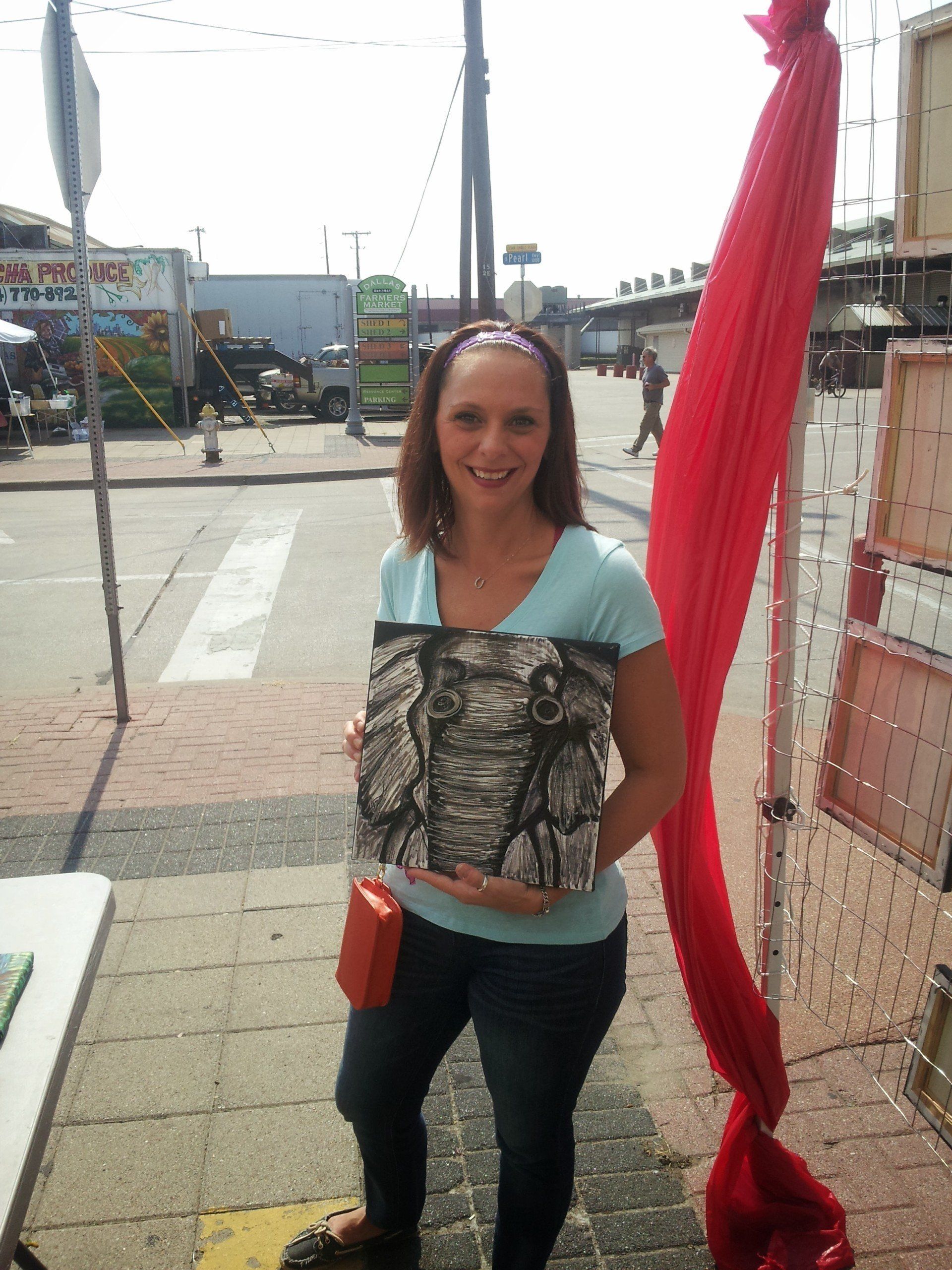A woman in a blue shirt is holding a purse