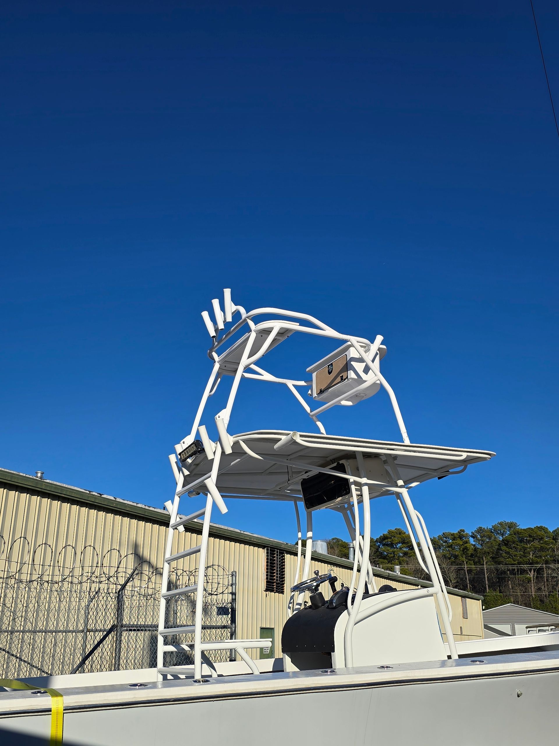 White boat tower against a clear blue sky; ladders and supports visible.