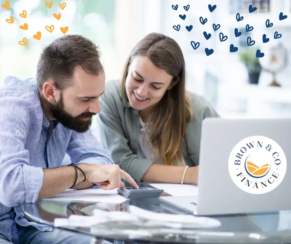 Two People at a Desk Looking at a Calculator — Brown & Co Finance in Gatton, QLD