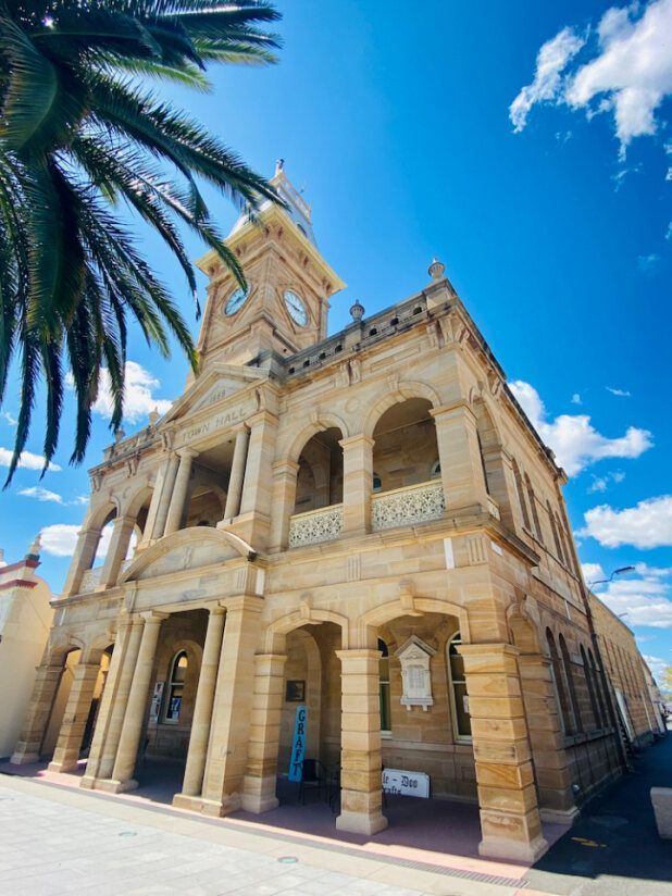 A Large Building With A Clock Tower And A Palm Tree In Front Of It — Brown & Co Finance in Warwick, QLD