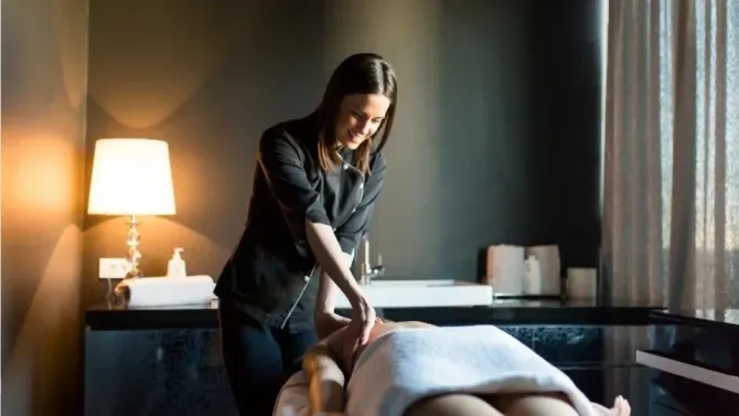 Massage therapist performing a treatment in a professional spa.