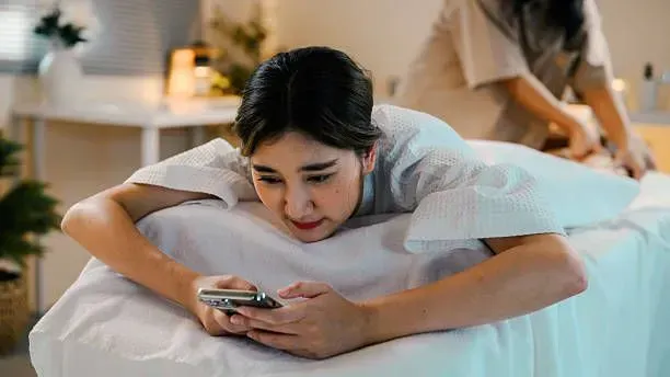 Relaxed woman resting on a massage table in a home setting.