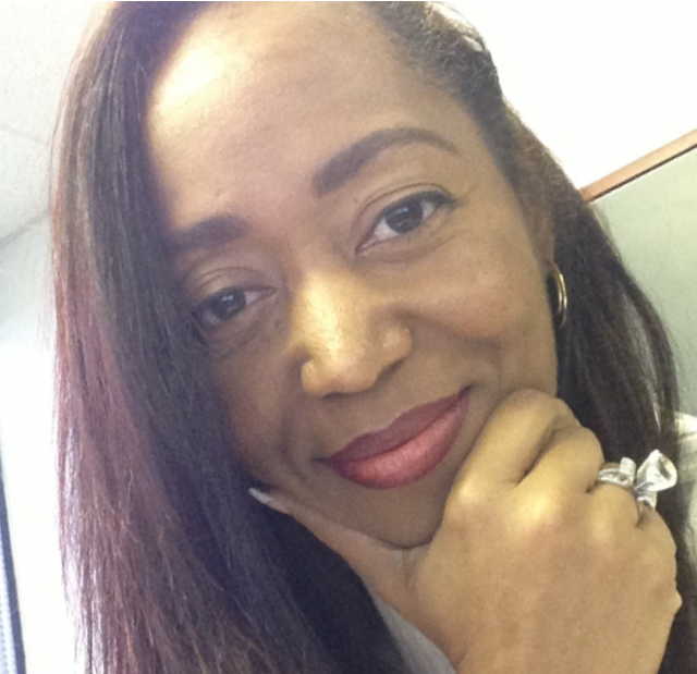 A woman with her hand on her chin and a ring on her finger