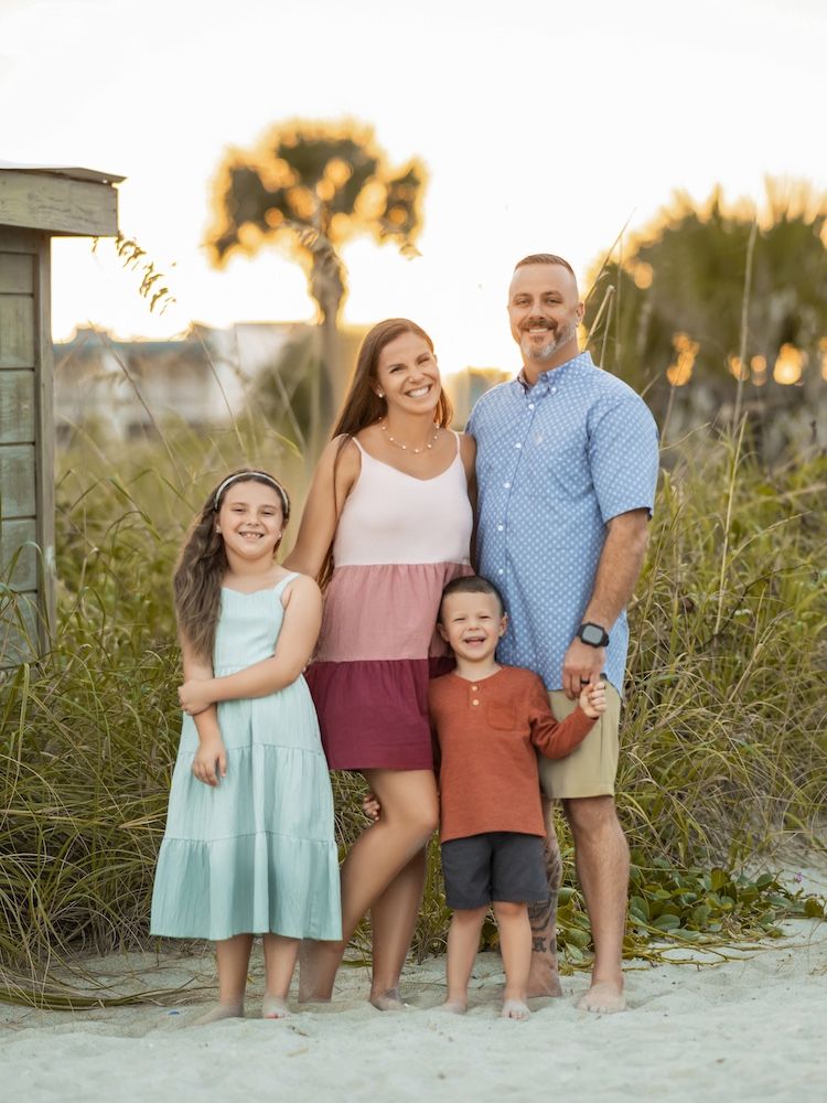 Woman with blonde hair holds pink peonies, sitting in a pink car.