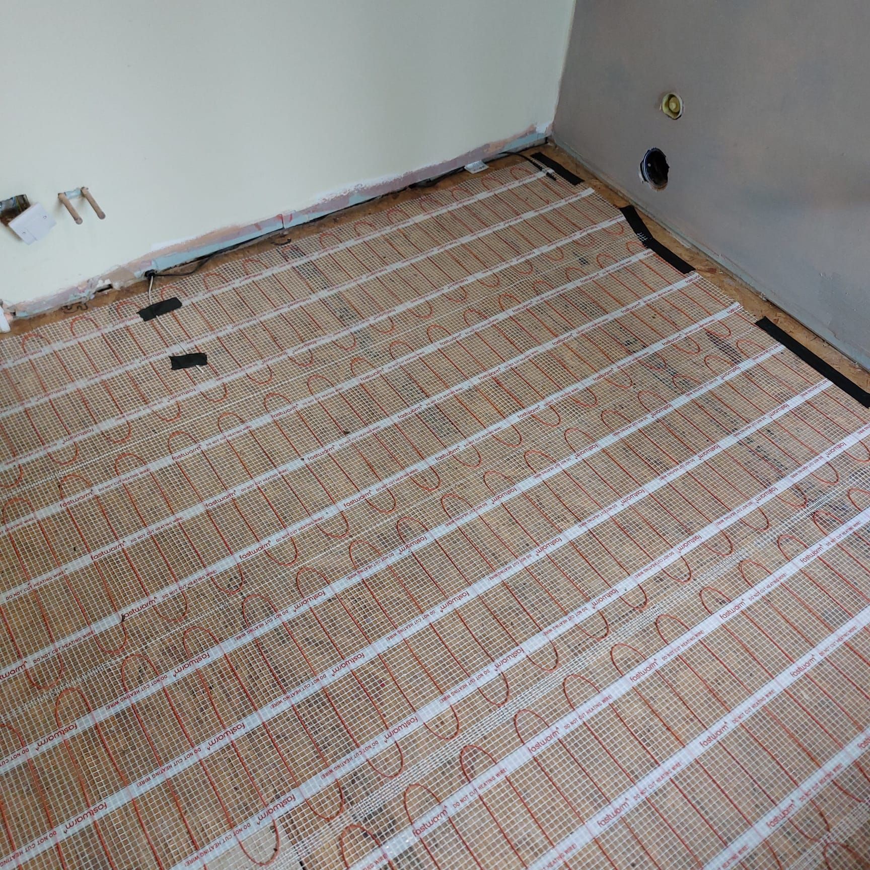 Electrician installing underfloor heating cables