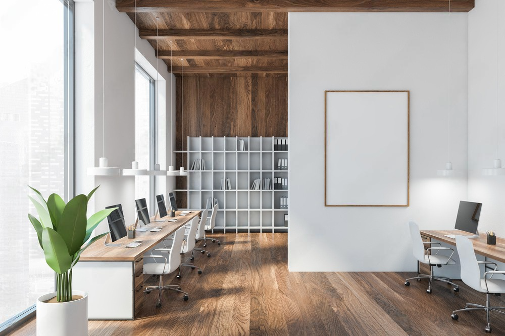 a modern office with wooden floors , white walls and a large window .