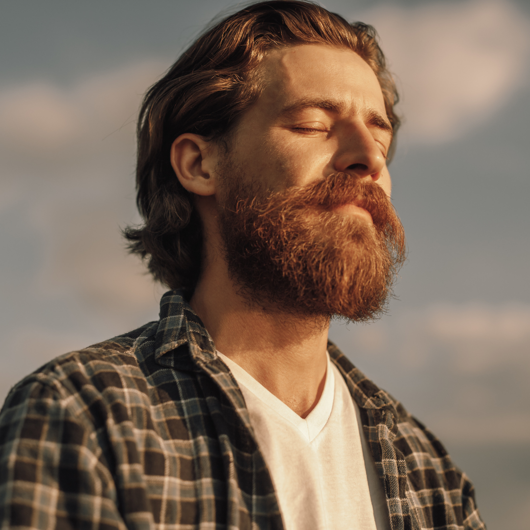 A child is writing on a piece of paper with a purple pencil.