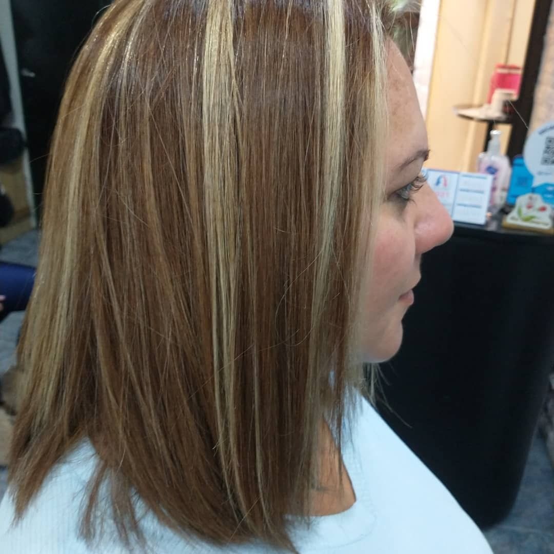 Perfil lateral de una persona con cabello castaño claro hasta los hombros, con prominentes reflejos rubios.