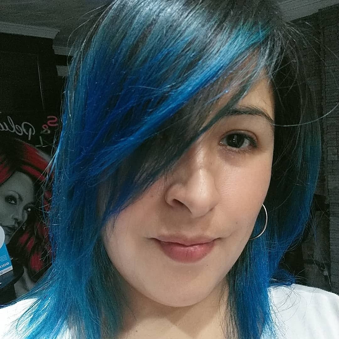Un primer plano de una persona con cabello azul vibrante hasta los hombros