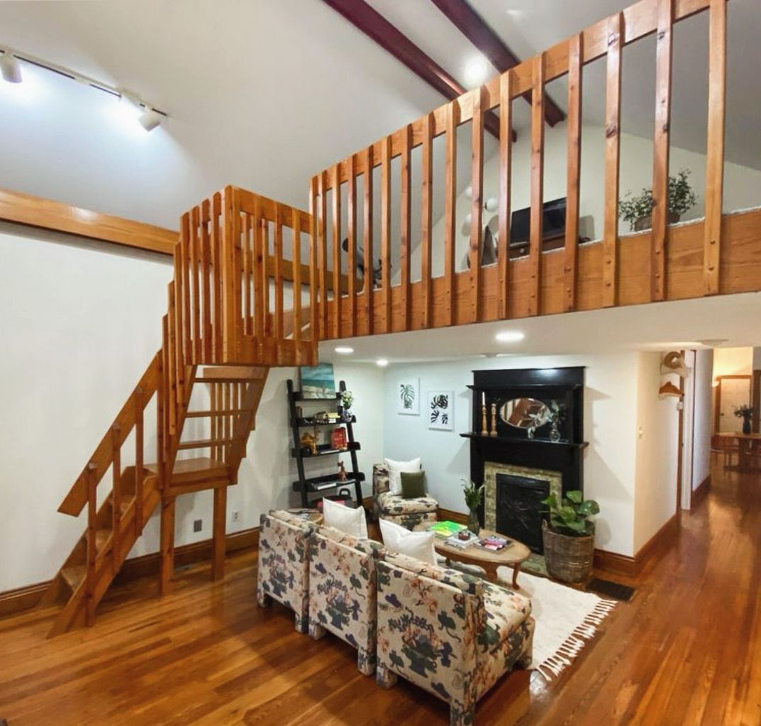 A living room with a staircase leading up to the second floor