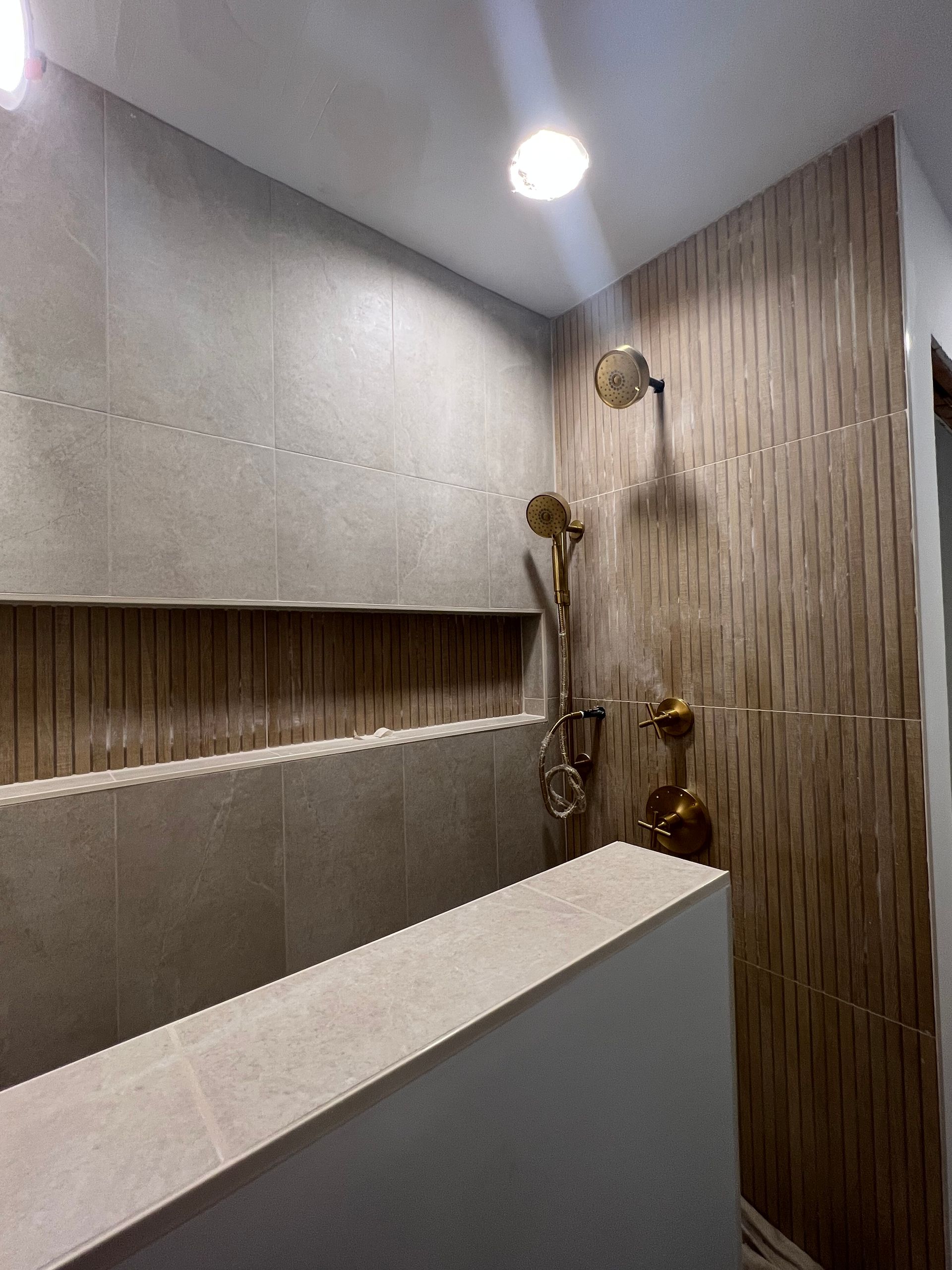 A bathroom with a shower , sink , and mirror.