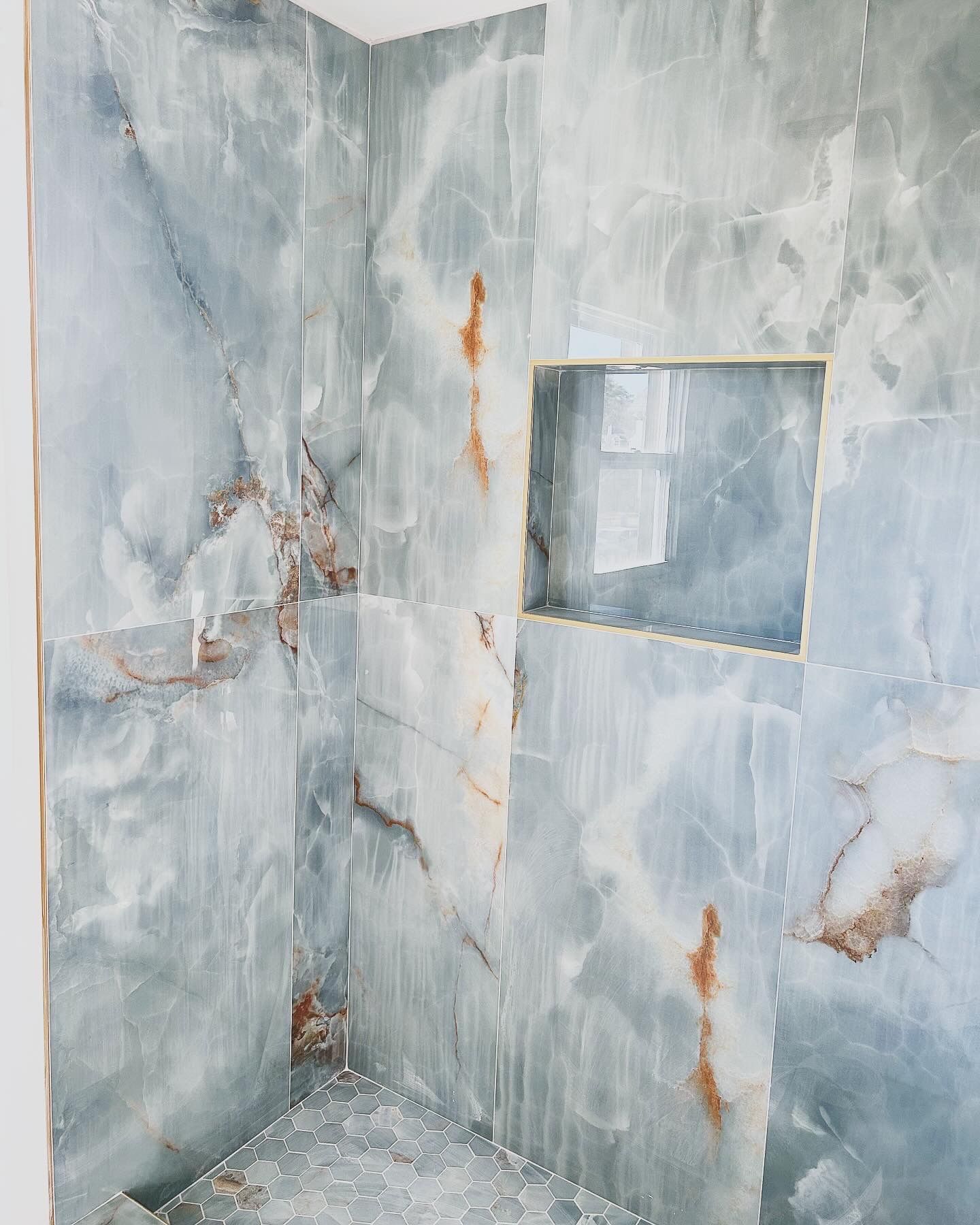 A bathroom with marble tiles and a niche in the wall