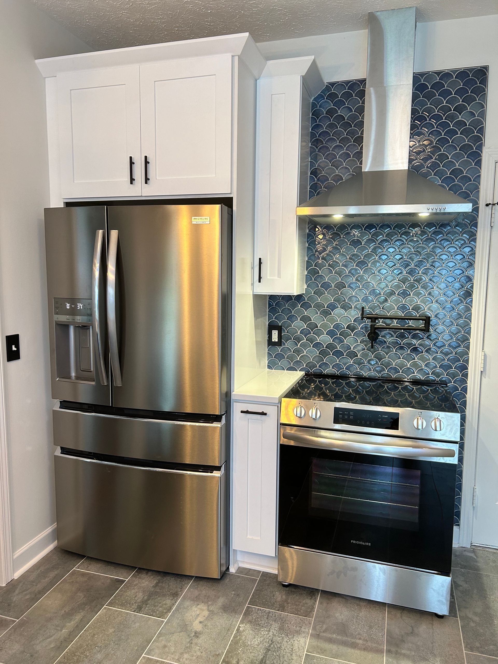A kitchen with stainless steel appliances and white cabinets