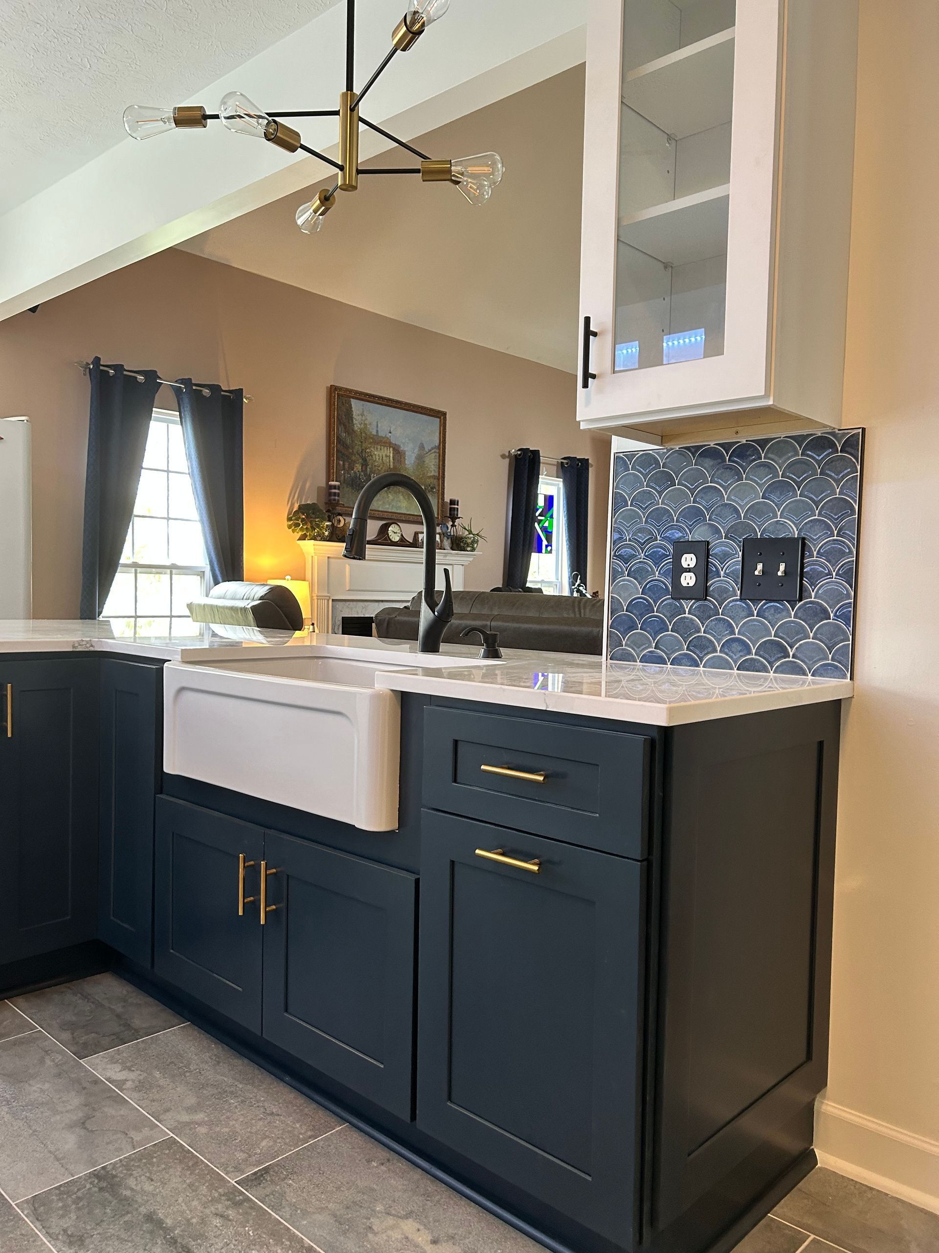 A kitchen with black cabinets and a white sink.