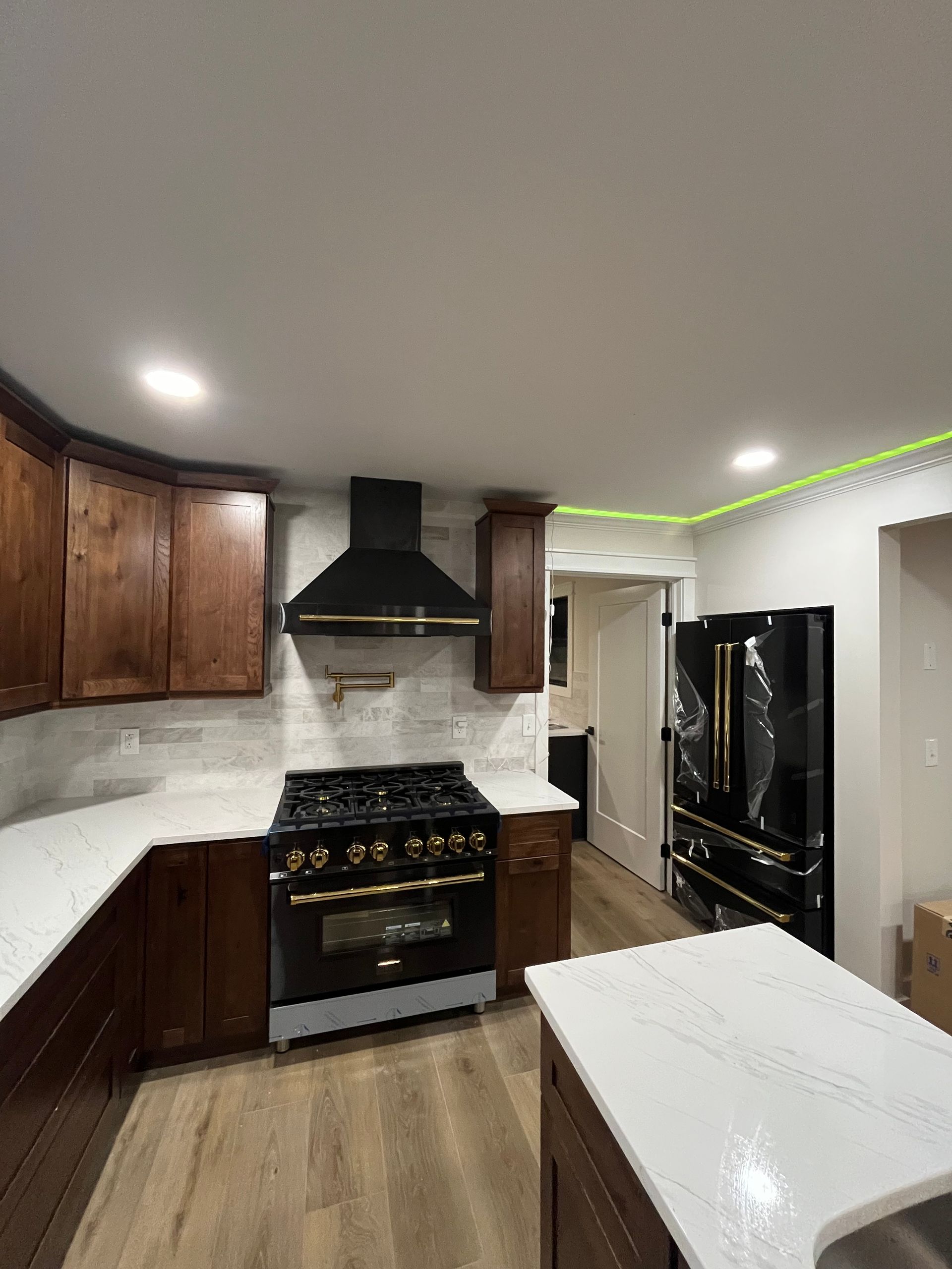 A kitchen with a stove , refrigerator , and sink.